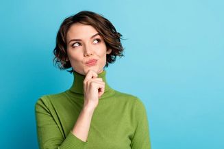Eine nachdenkliche Frau vor einem blauen Hintergrund.